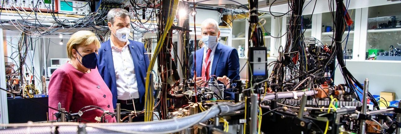 Bundeskanzlerin Angela Merkel und Ministerpräsident Markus Söder besichtigen ein Labor am Max-Planck-Institut für Quantenoptik.