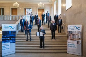 Die Präsidenten der am Munich Quantum Valley e.V. beteiligten Organisationen stehen auf einer Treppe. Martin Stratmann hält die Gründungsurkunde.