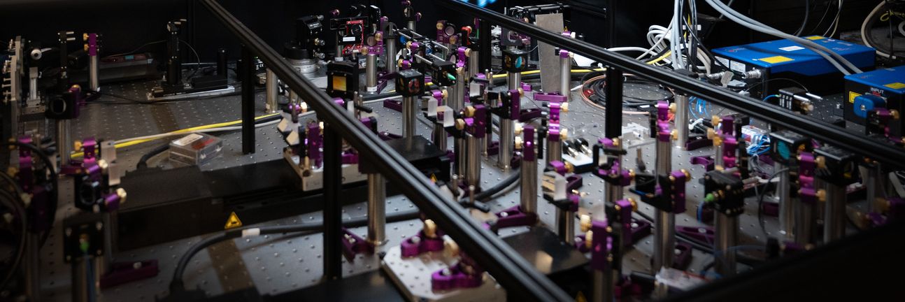 Eine Wissenschaftlerin steht vor ihrem optischen Experiment.