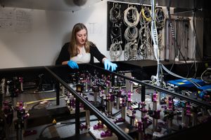 A female scientist stands in front of her optical experiment.